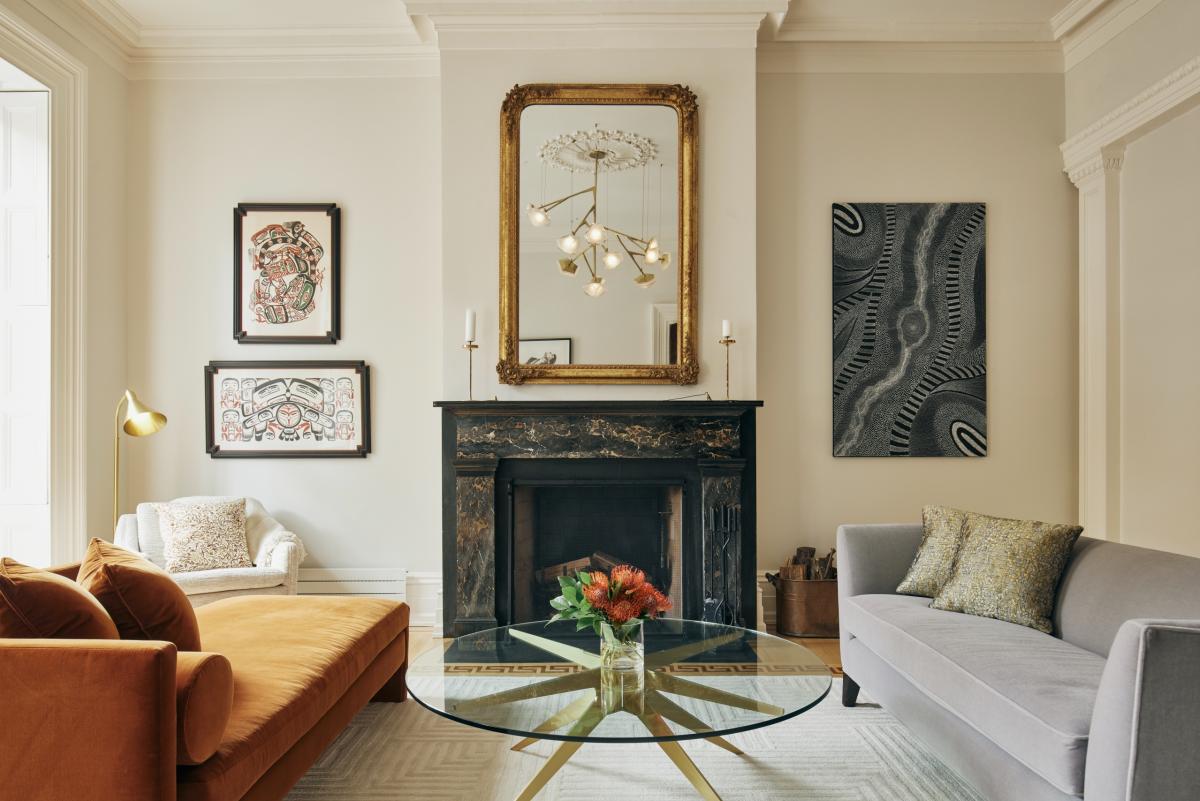 Gabriel Scott’s Myriad long chandelier in brass reflected in a mirror, installed in a luxury interior by Emma Montgomery